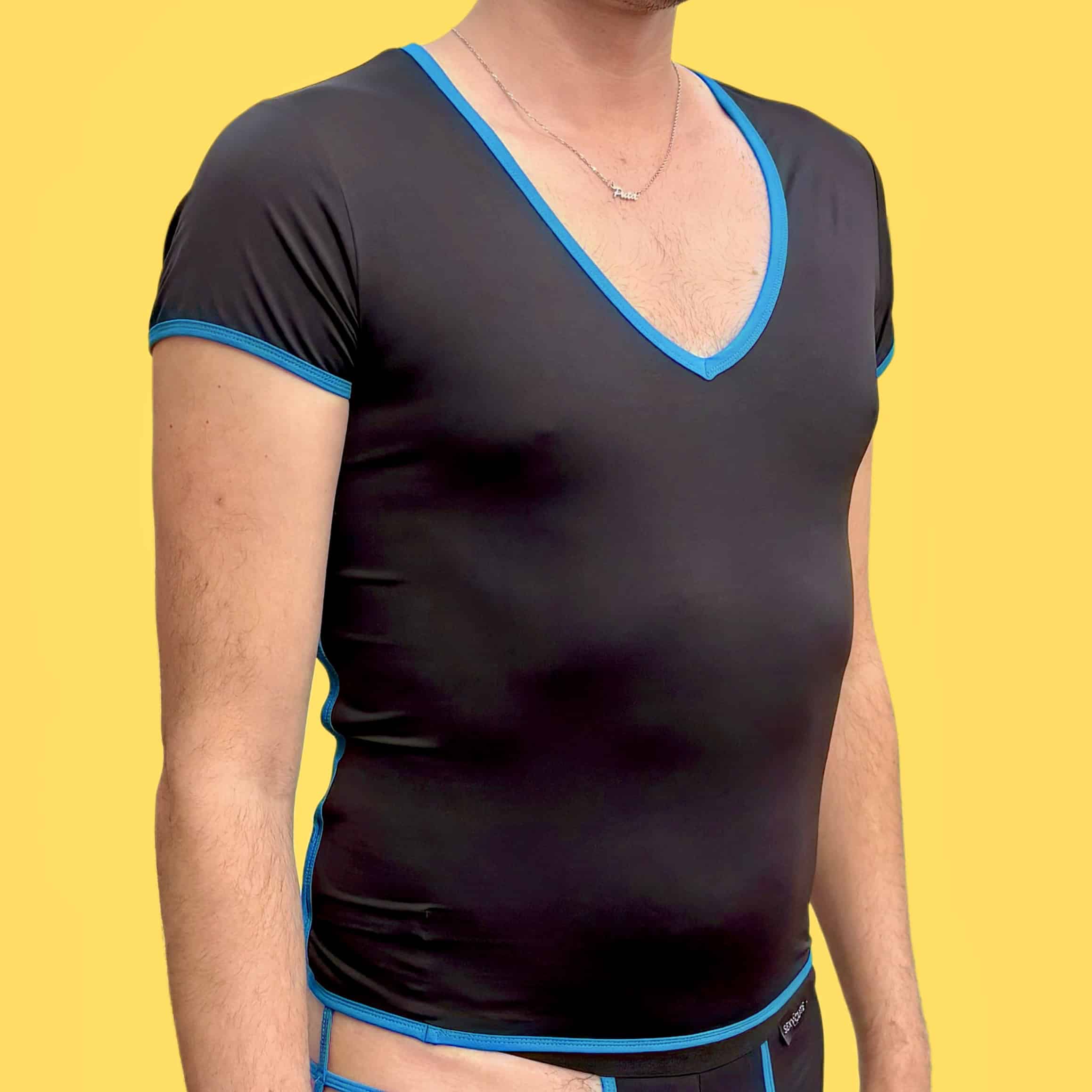 Hombre con camiseta negra y detalles azules en fondo amarillo.