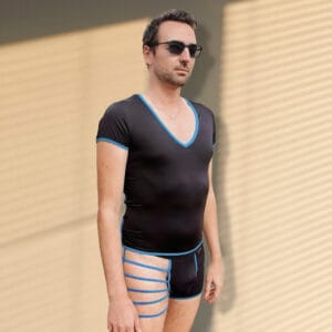 Hombre con ropa ajustada y gafas de sol en un entorno exterior.
