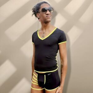 Mujer con gafas de sol, ropa deportiva negra con detalles en amarillo.