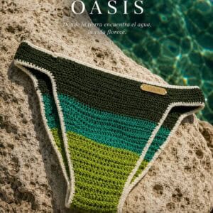 Bikini de crochet en tonos verdes y azules en roca junto al agua.