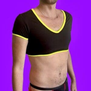 Boy wearing a black crop top with yellow details and a purple background.