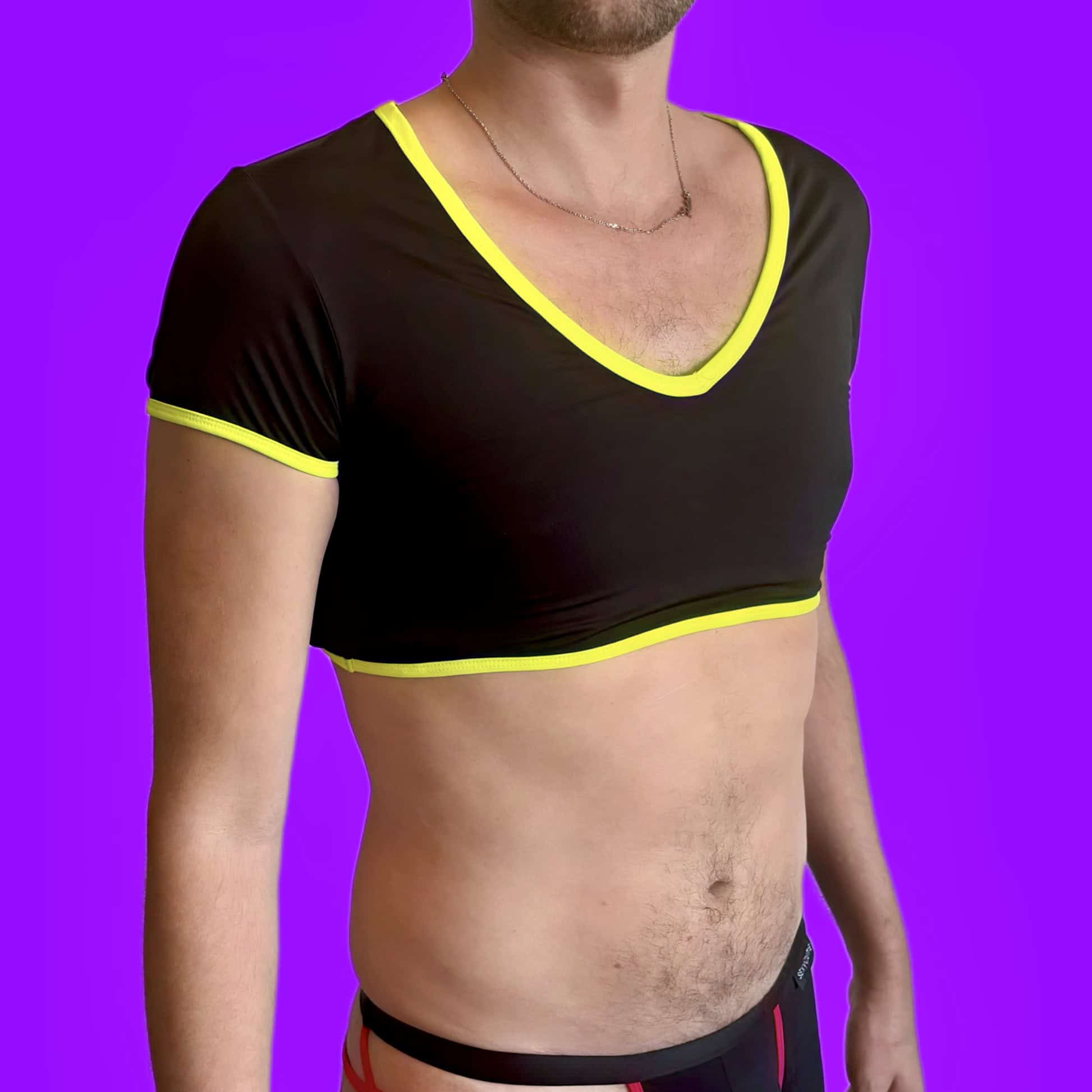 Garçon portant un crop top noir avec des détails jaunes sur fond violet.