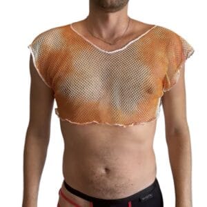 Garçon portant un crop top rose en résille et un pantalon noir sur fond blanc.