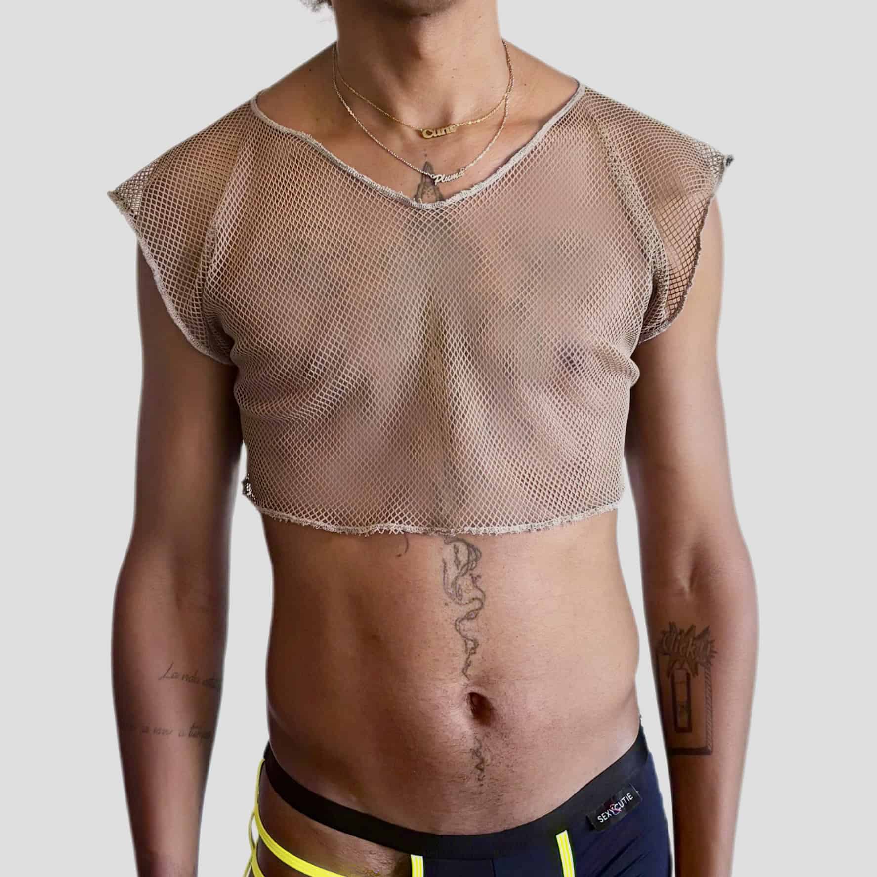 Jeune fille portant un haut en résille rose et un pantalon de survêtement noir avec des détails fluo.