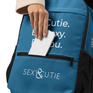 Bossa blava amb logo Sexy &amp; Cutie i telèfon mòbil a la butxaca frontal.